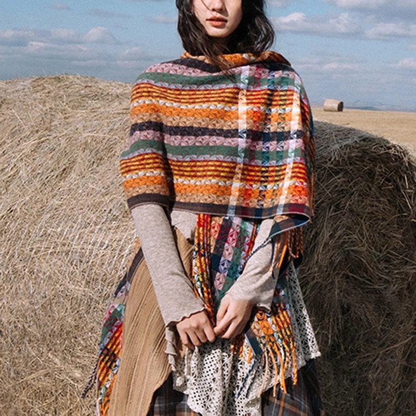 High-neck Tibetan tassel shawl with warm-tone stripes and collar-like wrap design showing side fringes in grassland