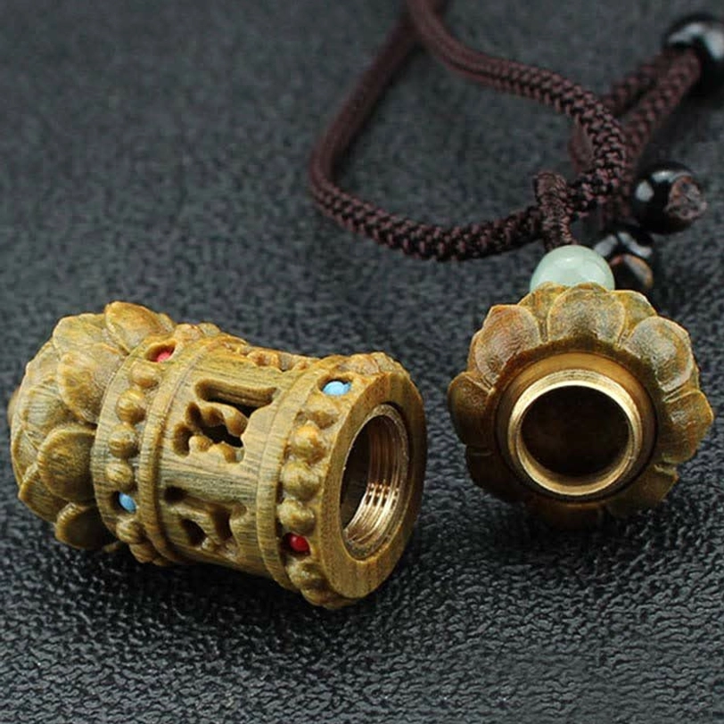 Detachable hollow green sandalwood prayer wheel pendant necklace with screw-on lotus cap, showing internal metal cavity structure