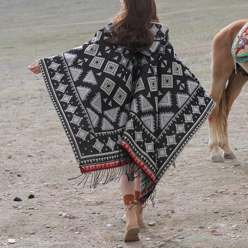 Black Tibetan hooded poncho with white tribal geometric pattern and fringe hem, rear view