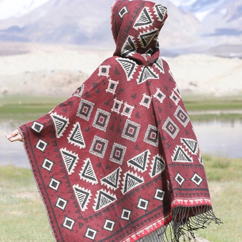 Folded Tibetan hooded cloak poncho displaying geometric tribal pattern and premium fabric quality