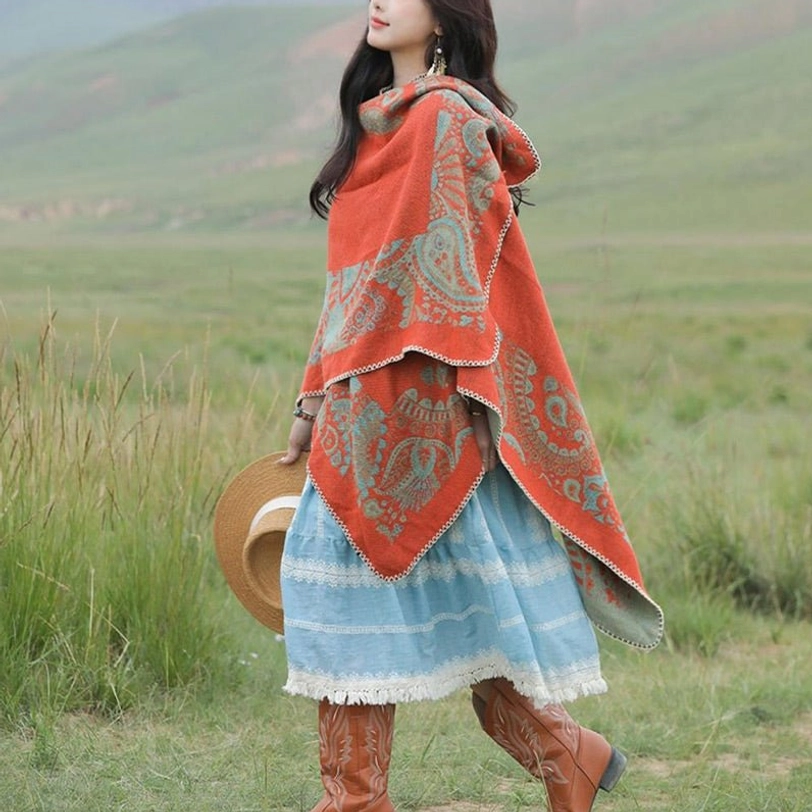 Hooded Tibetan paisley poncho with woven jacquard fabric, close side view in prairie outdoor environment
