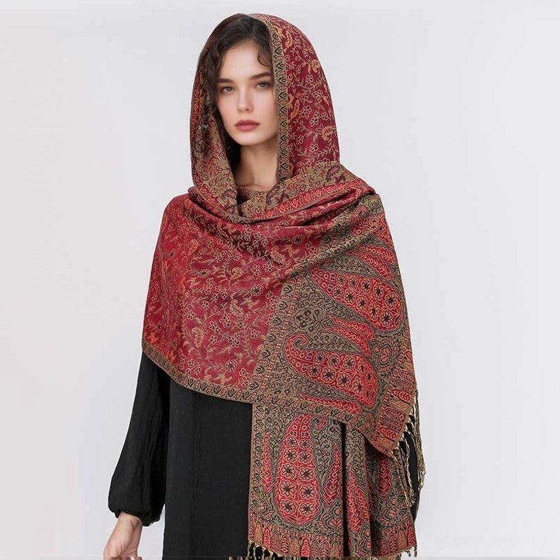 Model styling red base Tibetan hooded paisley shawl with brown decorative patterned panels, front view showing how to wear as protective head wrap