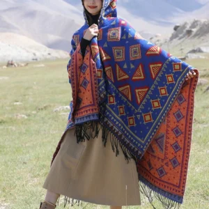 Blue Tibetan hooded poncho cloak with ethnic geometric tribal print and fringe hem, front three-quarter view