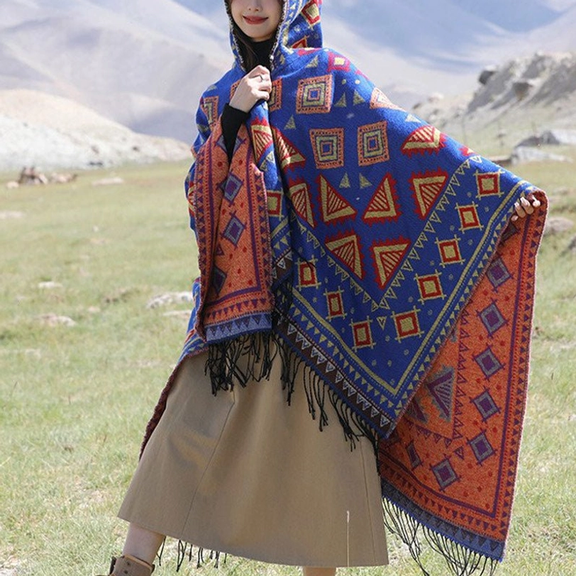 Blue Tibetan hooded poncho cloak with ethnic geometric tribal print and fringe hem, front three-quarter view