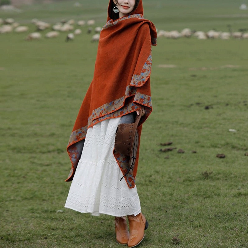 Tibetan hooded poncho worn casually with cowboy hat draped on hip, paired with brown boots on grassland