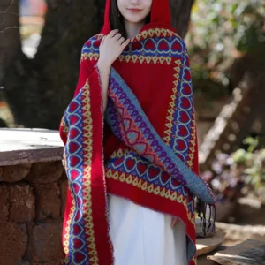 Tibetan ethnic cloak with attached hood worn, blue-yellow border prints visible, outdoor wooded setting