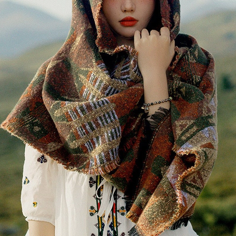 Hooded Tibetan tribal scarf wrap with thick warm fabric and rich geometric patterns, close-up front view in mountain outdoor area