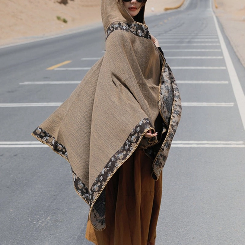 Brown Tibetan hooded shawl worn on grassland showing earthy tone color and traditional design elements