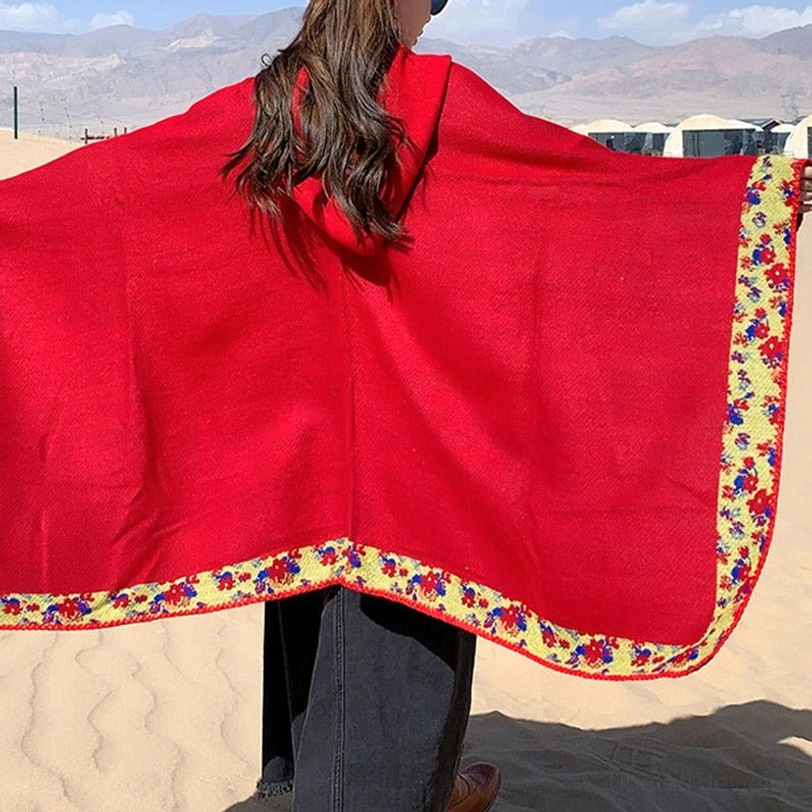 Orange Tibetan hooded wrap front close-up showing hood design and protective floral trim feature