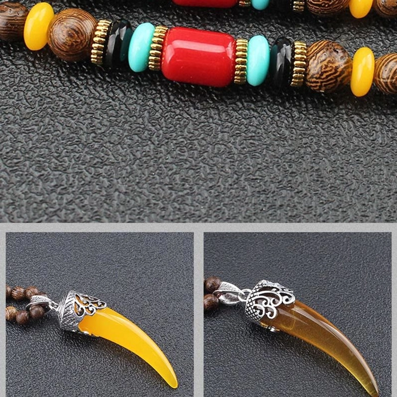 Extreme close-up of yellow horn pendant with ornate silver carved cap - intricate metalwork detail