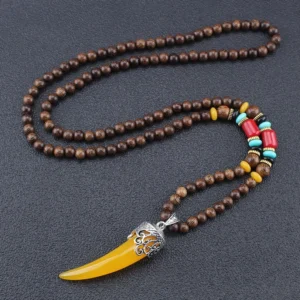 Yellow resin horn pendant necklace with wenge wood beads and turquoise accents - Tibetan inspired protection amulet flat lay