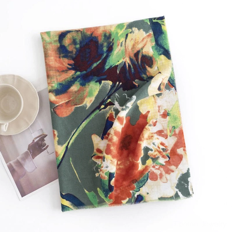 Dark green Tibetan floral scarf with rust watercolor flower pattern flat laid beside coffee cup and vintage magazine
