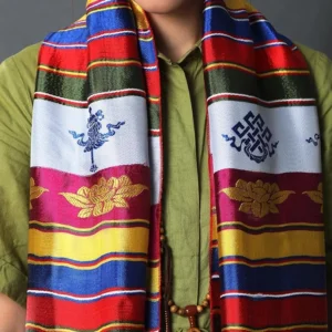 Close-up detail of Tibetan khata scarf showing Buddhist embroidery patterns and silk texture with prayer beads