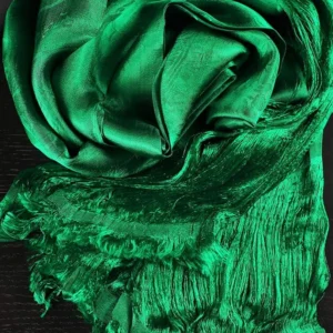 Close-up detail of green tibetan khata showing intricate jacquard weaving pattern and glossy silk texture