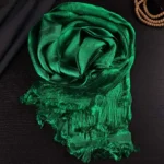 Tibetan green 5-color jacquard khata silk scarf with frayed tassels, overhead flat lay on dark wooden table