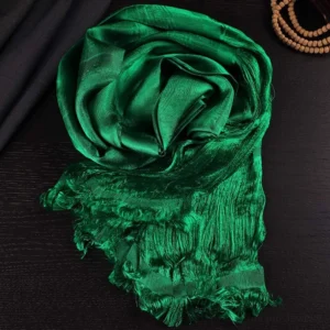 Tibetan green 5-color jacquard khata silk scarf with frayed tassels, overhead flat lay on dark wooden table
