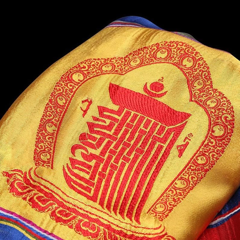 Tibetan khata showing red Kalachakra embroidery, ornate decorative borders, and yellow silk-like fabric base
