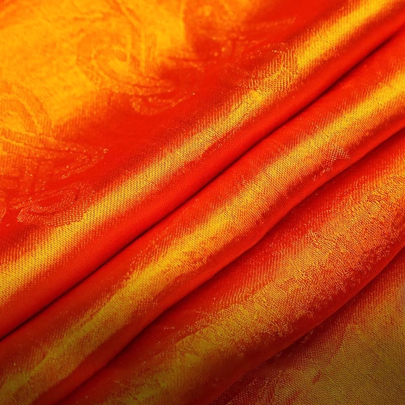 Orange tibetan khata fabric detail showing ombre jacquard pattern with paisley design and glossy finish