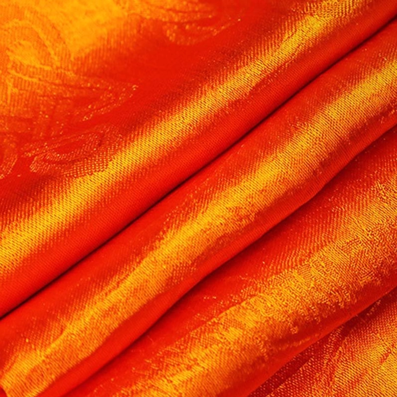 Red-orange tibetan khata scarf close-up displaying warm reddish-orange jacquard weave and satin texture