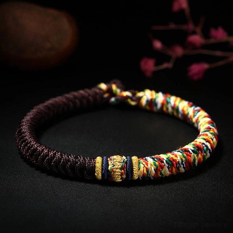 Brown Tibetan King Kong Knot braided bracelet with multicolored woven details dark backdrop