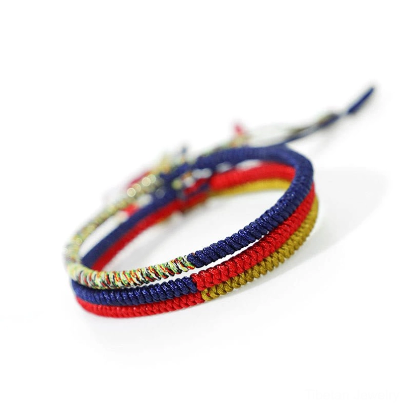 Tibetan King Kong Knot handmade braided protection bracelet featuring red, navy blue and gold multicolor woven design on white background