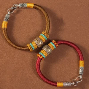 Pair of Tibetan King Kong Knot braided protection bracelets in red and brown with matching decorative hardware and beads