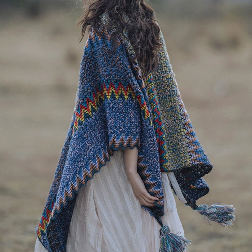 Back view of Tibetan knit cape featuring zigzag ethnic stitch pattern, draped fit with hanging tassels