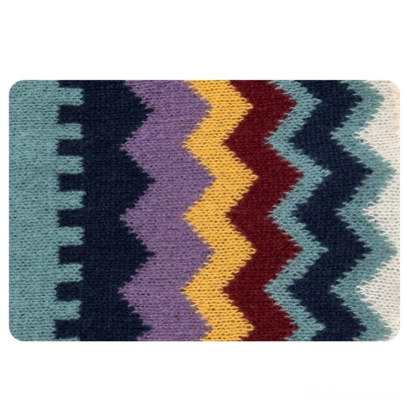 Tibetan knit shawl wrap draped display showing full length with zigzag pattern, ruffled edges and tassel details