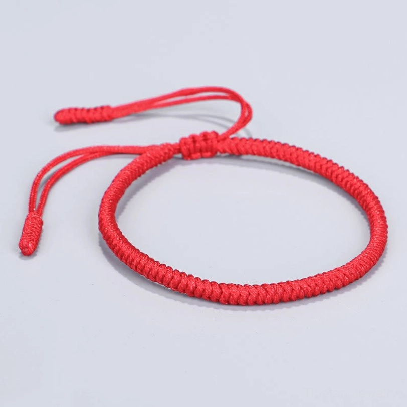 Flat lay front view of Tibetan King Kong knot braided bracelet in solid bright red with traditional woven rope design