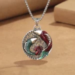 Tibetan copper koi fish pendant necklace with pearl chain, 45-degree close-up view showing detailed enamel red-green koi design on kraft paper background