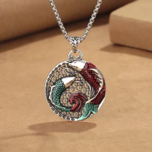 Tibetan copper koi fish pendant necklace with pearl chain, 45-degree close-up view showing detailed enamel red-green koi design on kraft paper background