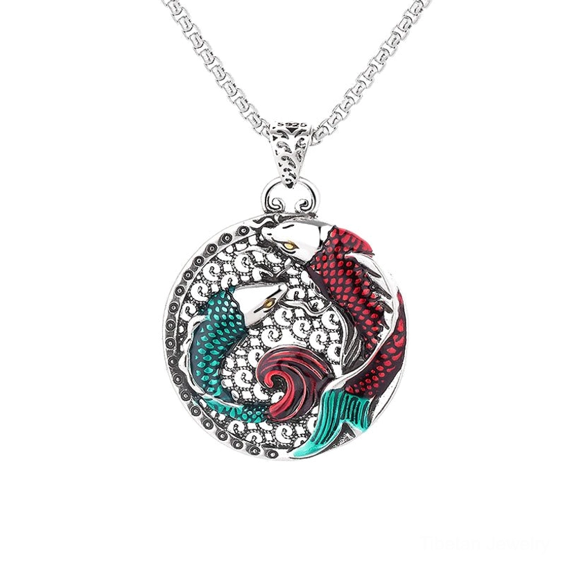 Koi fish round pendant necklace with vibrant red-green enamel design and silver chain, top-down close-up on white background