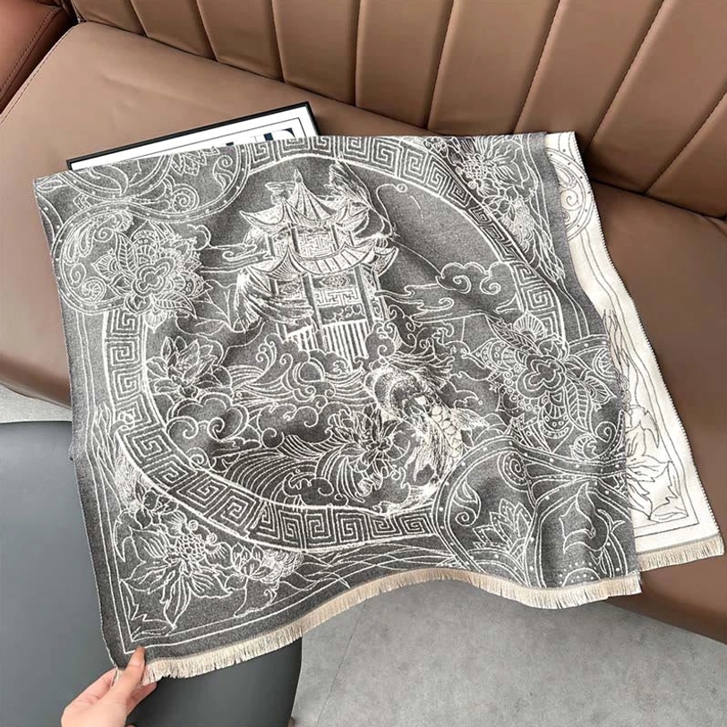Flat lay overhead view of Tibetan pavilion koi fish scarf displaying full artistic pattern with off-white fringed hem on home interior background