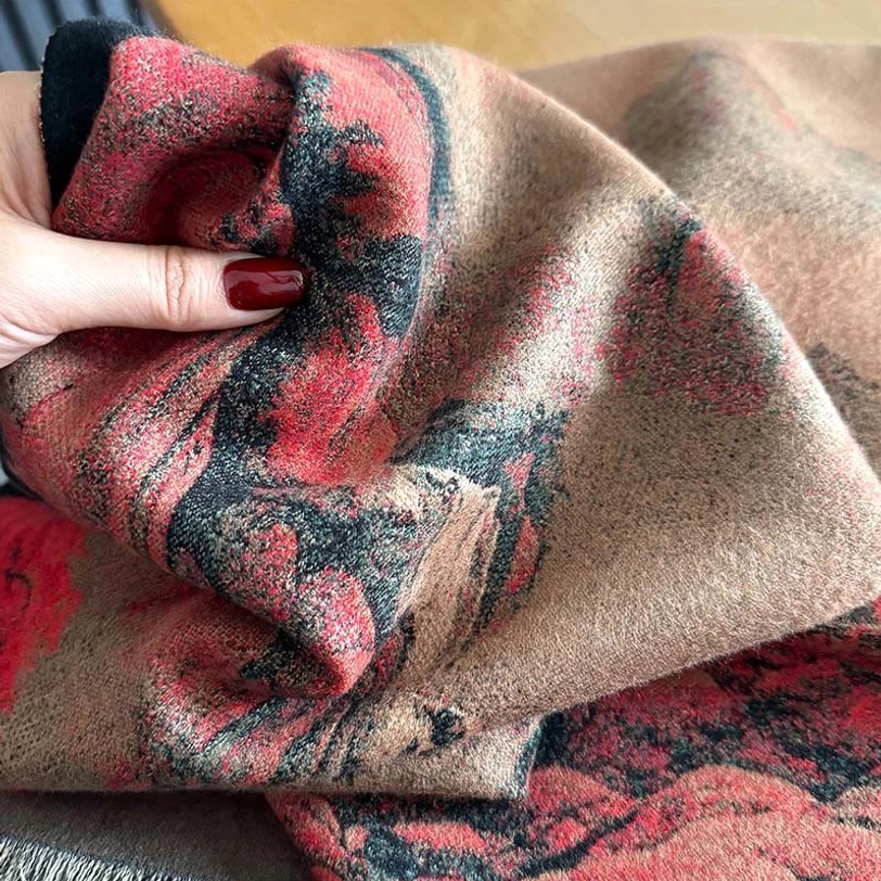 Close-up macro detail of Tibetan scarf fabric texture showing thick plush weave, crumpled surface, and red-brown landscape print in fine detail