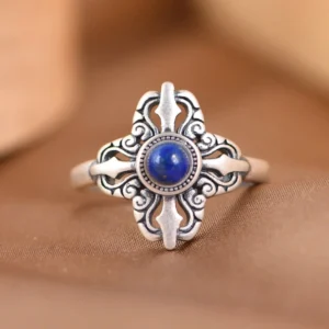 Tibetan sterling silver lapis lazuli ring with traditional cross pattern, front view on brown background