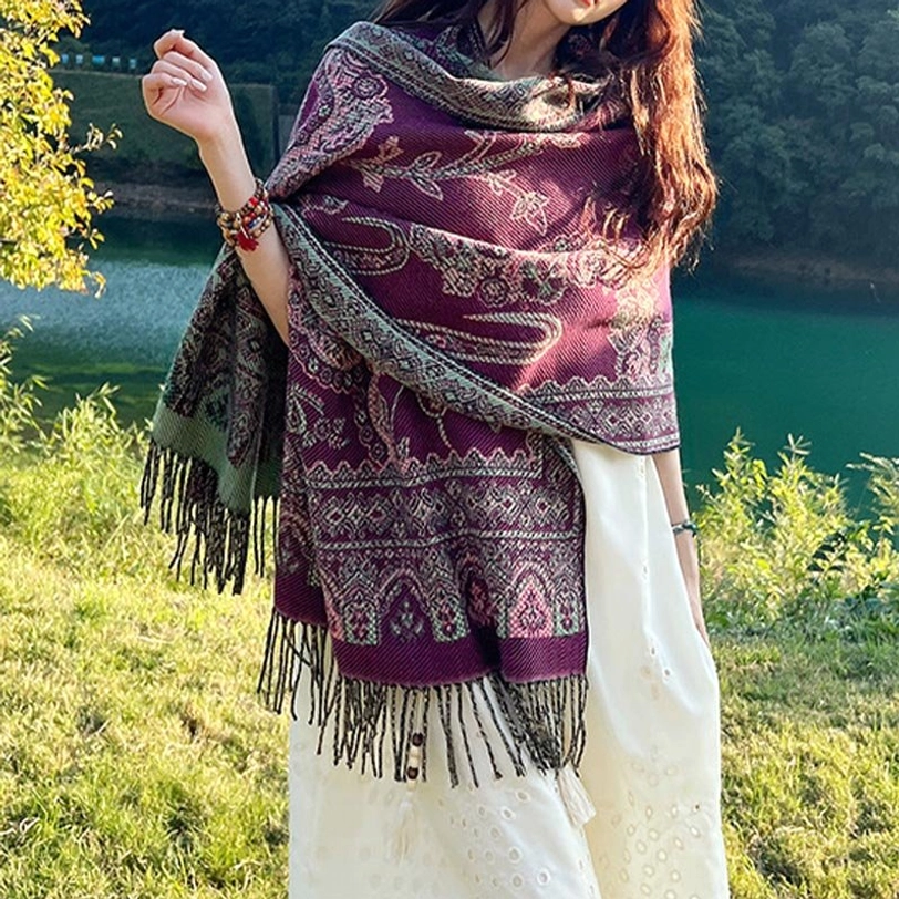 Woman wearing purple Tibetan botanical shawl with leaf paisley patterns at sunny lakeside, front three-quarter view