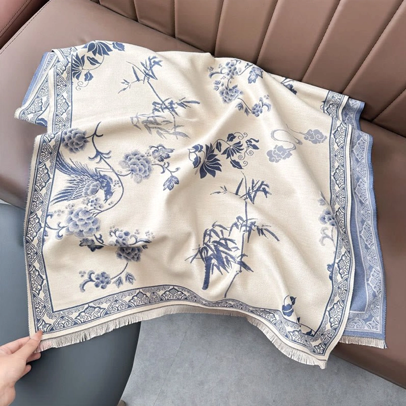 Light steel blue Tibetan bird and bamboo leaf scarf laid flat on surface