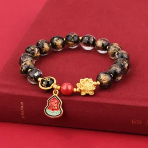 Handcrafted Tibetan Liuli glass beaded bracelet with spotted beads and sacred Sanskrit charm displayed on red book surface