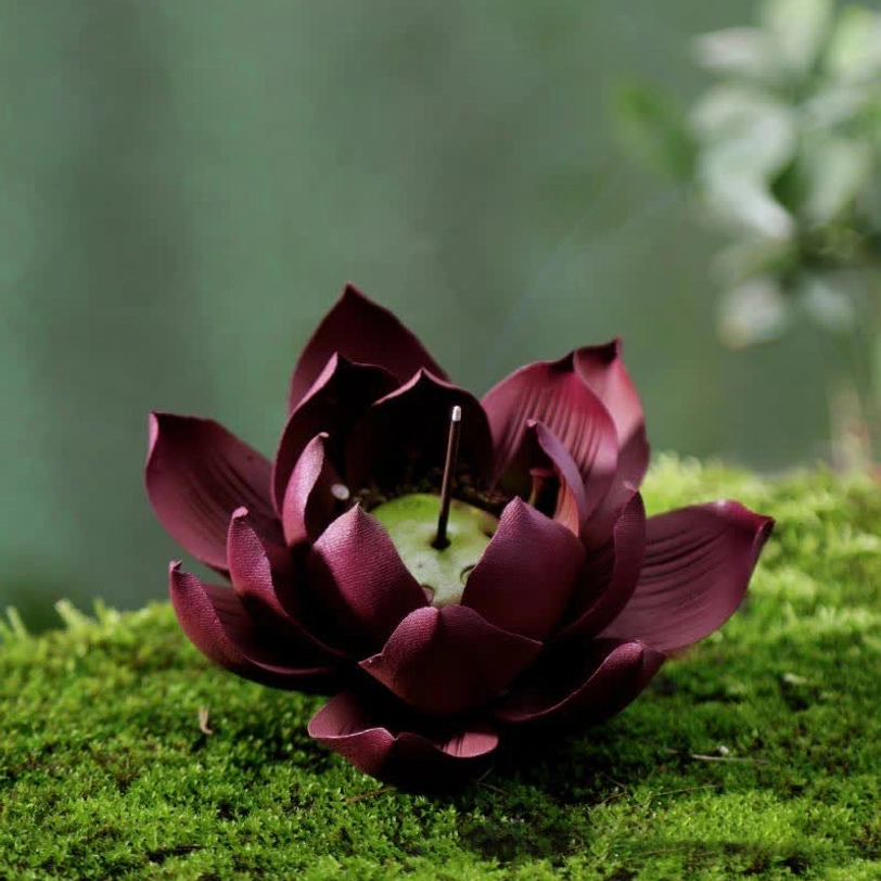 Tibetan lotus incense holder three-quarter view showing dark wine red clay and green lotus seed pod cavity interior design