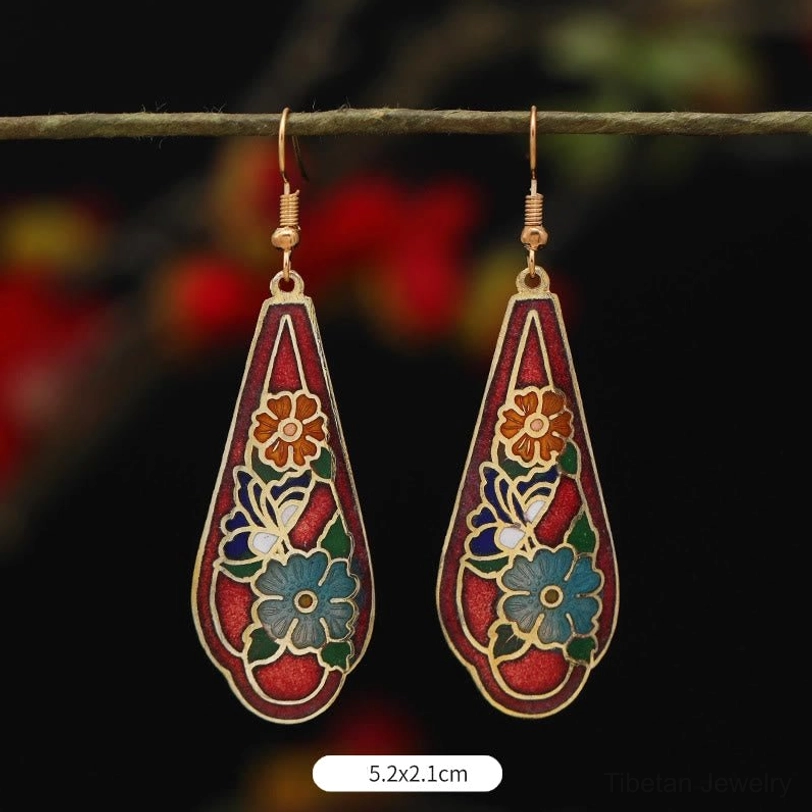 Floral and butterfly patterned teardrop drop earrings 5.2x2.1cm with red base and multi-color floral motifs, gold tone trim on twig display
