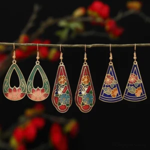 Six pairs of assorted Tibetan lotus and butterfly enamel drop earrings in multiple colors displayed on twig, feng shui symbol jewelry collection