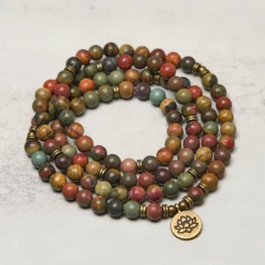 Lotus mala prayer beads side view displaying natural stone texture and brass charm detail on light background