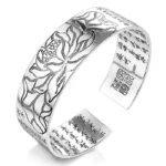 Tibetan lotus white copper open cuff bracelet with engraved lotus flower and sacred sutra text, front three-quarter view on studio background