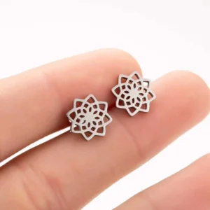 Tibetan lotus stud earrings silver finish held on fingertip showing intricate hollow cutout design
