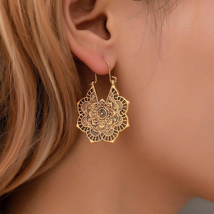 Tibetan lotus drop earrings on model ear closeup antique finish secure ear hook detail
