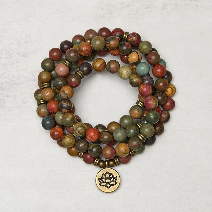 Red turquoise lotus charm mala bracelet 108 beads top view showing multi-layer coiled beads with brass lotus pendant on gray background
