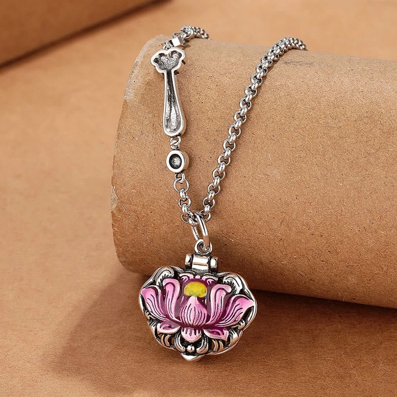 Pink enamel lotus pendant necklace with vintage copper chain, oblique view on kraft paper background