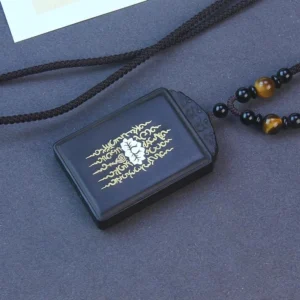 Ebony wood lotus pendant with inlaid sterling silver, front view showing carved lotus design and beaded cord necklace