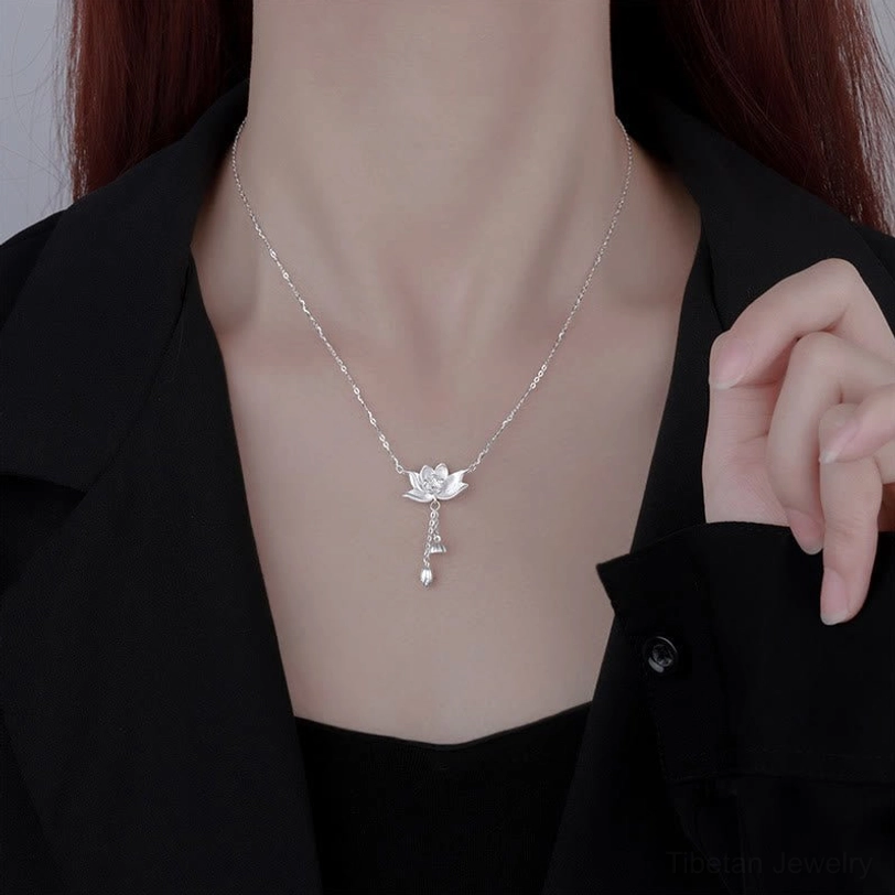 Worn on collarbone: sterling silver lotus pendant necklace styled with black blazer, spiritual meditation jewelry