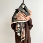 Tibetan lotus mountain shawl in sandy brown with ink wash landscape print, three-quarter draped view on mannequin with brown wool coat